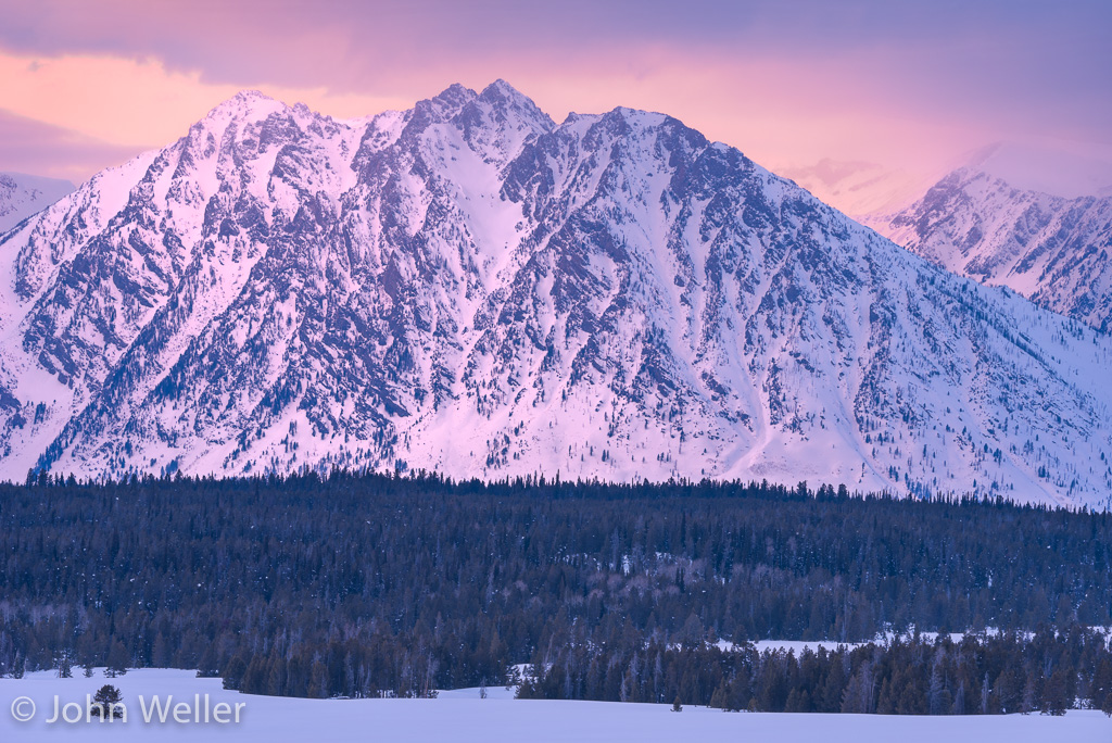 The warm glow of sunset lights up the Tetons.
